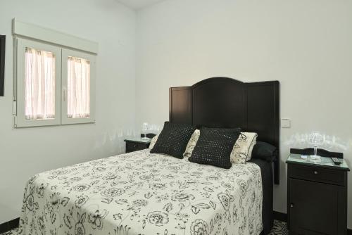 a bedroom with a bed with a black and white comforter at Marisol' House in Puente Genil