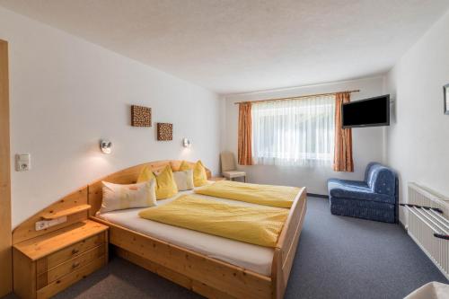 a bedroom with a large bed and a blue chair at Ferienwohnung Valentina in Schwendau
