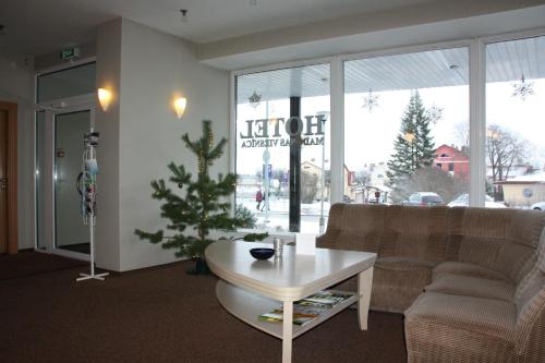 a living room with a couch and a christmas tree at Hotel Madona in Madona