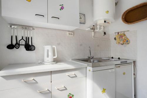 a small kitchen with white cabinets and a sink at Ferienbungalows Werner in Koserow