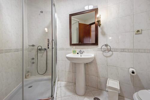 a bathroom with a sink and a shower and a mirror at Moinho de Paradela in Paradela