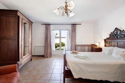 a bedroom with a large bed and a chandelier at Moinho de Paradela in Paradela