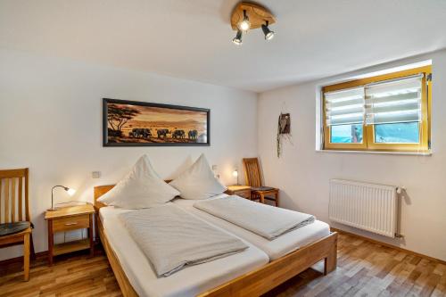 a bedroom with a bed with white sheets and a window at Ferienwohnung Graf in Lauf