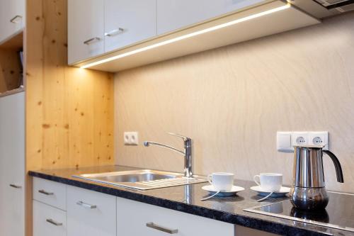 a kitchen with a sink and two cups on a counter at Schloss Gravetsch in Villandro