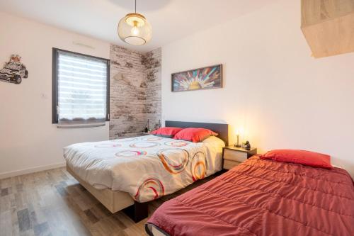 a bedroom with two beds and a window at Paradi Bleu in Trégunc