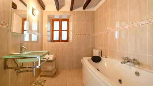 a bathroom with a bath tub and a sink at Sol y Montes in Fornalutx