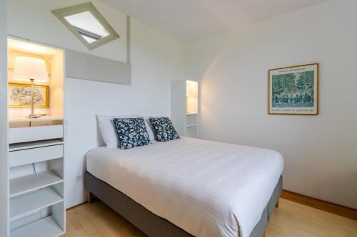 una camera da letto bianca con un letto e una finestra di Maison La Barge a Cubjac