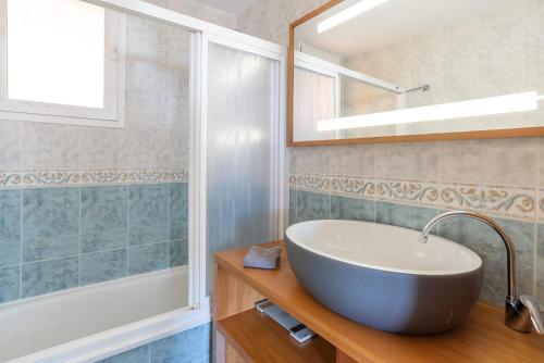 a bathroom with a sink and a tub and a mirror at Modern penthouse in Fuengirola