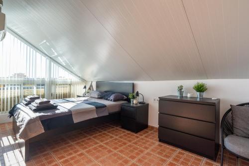 a bedroom with a bed and a large window at Modern penthouse in Fuengirola