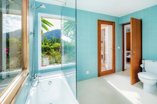 a bathroom with a tub and a toilet and a window at Casa en Centro Histórico Pollença in Pollença