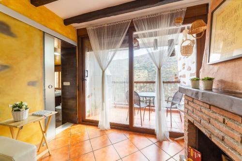 a living room with a fireplace and a balcony at La Casa Al Revés in Laroya