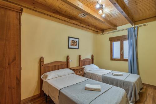 a room with two beds and a window at El Alarife in Sediles