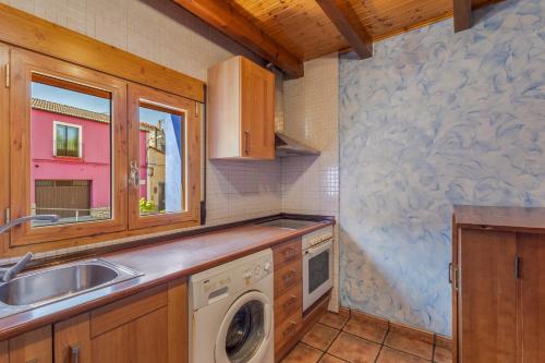 a kitchen with a sink and a washing machine at El Alarife in Sediles