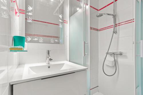 a white bathroom with a sink and a shower at Studio Saint Clair pieds dans l'eau in Le Lavandou
