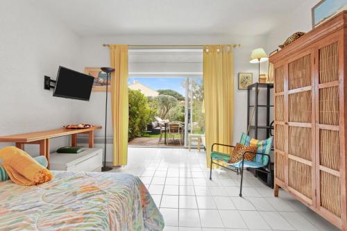 a bedroom with a bed and a desk and a table at Studio Saint Clair pieds dans l'eau in Le Lavandou