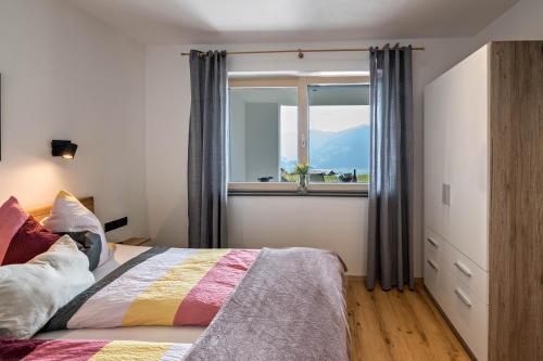 a bedroom with a bed and a large window at Ferienwohnung am Mühlbachl in Rohrberg