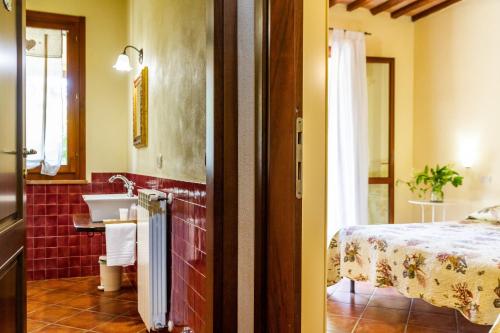 a bathroom with a sink and a bed in a room at Il Gaggiolo 2 in Grosseto