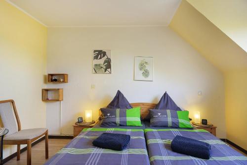 a bedroom with a bed with blue and green pillows at Eifelferienhaus Thome Lissendorf in Lissendorf