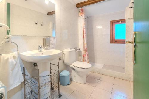 a bathroom with a sink and a toilet and a shower at Can Guidic in Bas