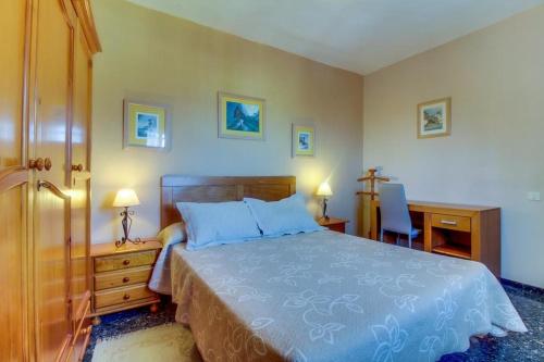 a bedroom with a blue bed with a desk and a chair at Villa Morera in Arafo