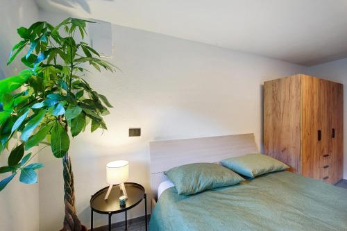 a bedroom with a bed and a potted plant at La Pièce de Leo in Châtillon
