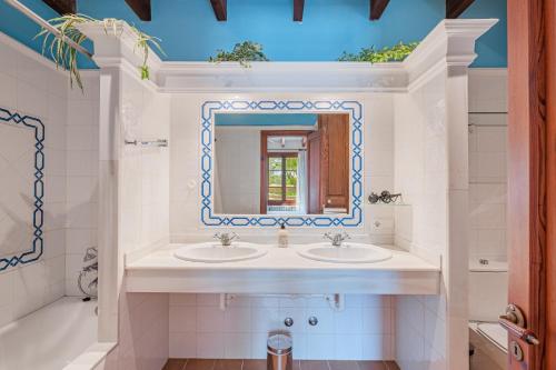 a bathroom with two sinks and a mirror at Els Marsals in Llucmajor