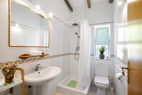a white bathroom with a sink and a toilet at Casa Noah in São Bartolomeu de Messines