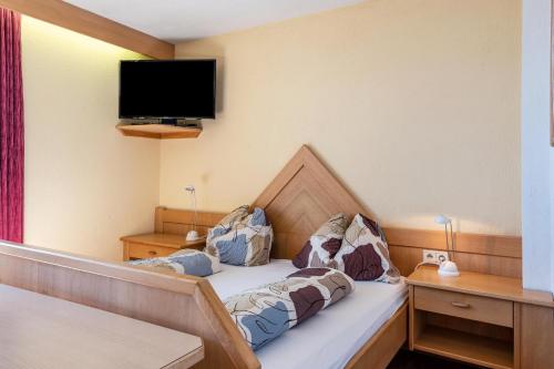a bedroom with a bed with a tv on the wall at Apt Waldblick in Maranza