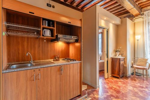 a kitchen with wooden cabinets and a sink at Romantic Apartment Near Pisa Lucca in Bientina