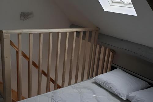 a crib in a room with a bed and a window at La Maison Defanny - 2 in Muides-sur-Loire
