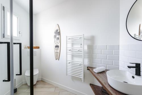 a white bathroom with a sink and a toilet at La Terrasse, Rivedoux Beach House in Rivedoux-Plage