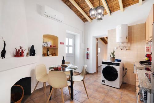 a kitchen and dining room with a table and chairs at Casa Gotinha d' Água in Alcaria Ruiva