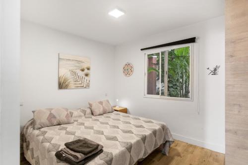 a white bedroom with a bed and a window at Daniel House in Mogán