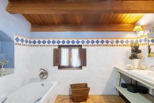 a bathroom with a tub and a sink at Casa Romaní in El Bruc