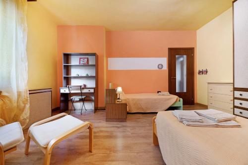 a room with two beds and a desk in it at Casa Giuly in Stazzona