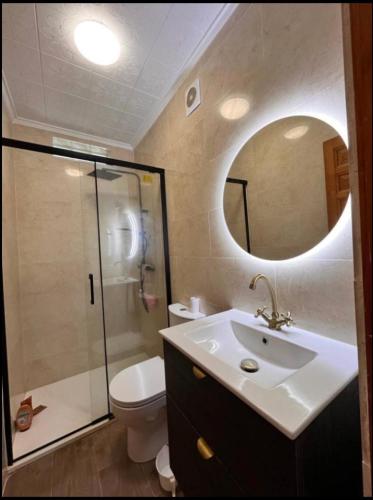 a bathroom with a toilet and a sink and a mirror at Sam in San Fulgencio