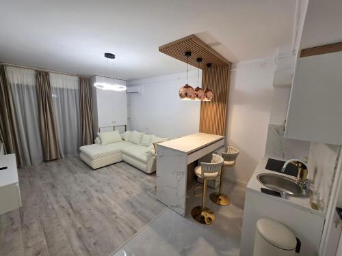 a kitchen and living room with a couch and a sink at Apartament DeLux cu Jacuzzi Caciulata in Căciulata