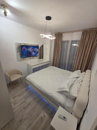 a bedroom with a bed and a couch and a window at Apartament DeLux cu Jacuzzi Caciulata in Căciulata
