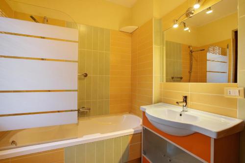 a bathroom with a sink and a tub and a mirror at Maison Chateau Chatillon in Châtillon