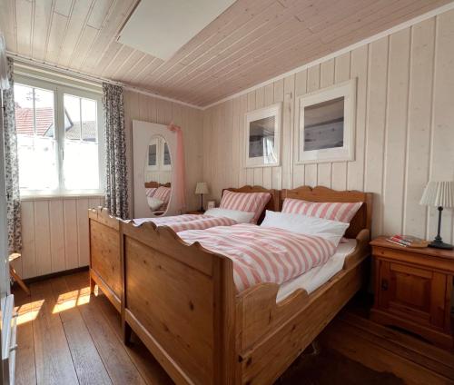 a bedroom with a large wooden bed and a window at Kanne Honeymoon Apartment in Trichtingen