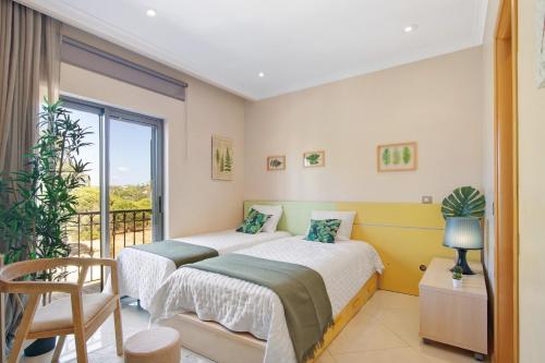 two beds in a room with a balcony at Sunshine Villa em Vilamoura in Vilamoura