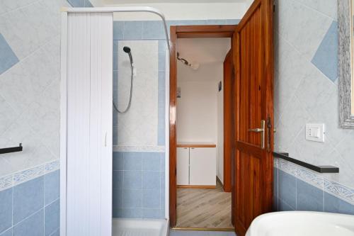 a bathroom with a shower and a toilet and a door at Villa Elena in Castelsardo