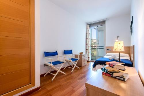 a bedroom with a bed and a desk and a table with books at Duplex La Nau By homevillas360 in Port de Pollensa