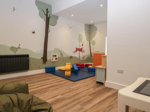 a childrens room with a mural of a tree and animals at Beech Timber Lodge in Keswick