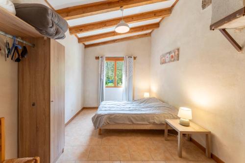 a bedroom with a bed and a table in a room at La Petite Palasse in Le Thor