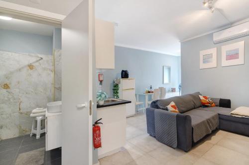 a living room with a couch and a kitchen at Apartamento Sun7set in Quarteira