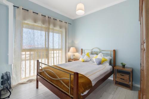 a bedroom with a bed and a large window at Apartamento Sun7set in Quarteira