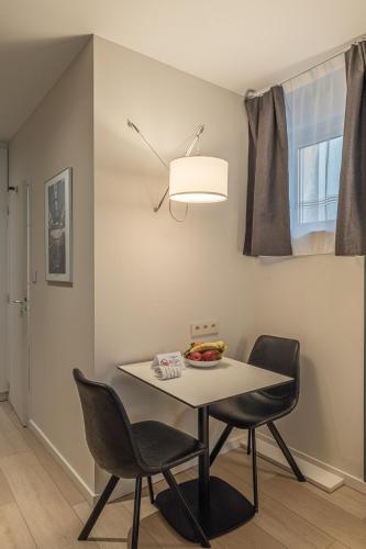 una sala da pranzo con un tavolo e due sedie di Five Resort Cholet Centre a Cholet