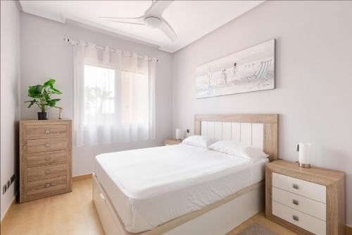 a white bedroom with a white bed and a window at Golf And Sun in Los Alcázares