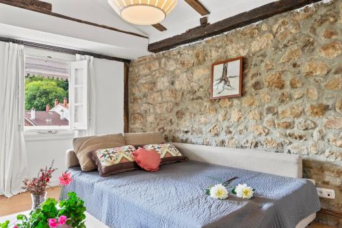 a bedroom with a bed and a stone wall at Apartamento 3 Casa Las Indianas in Selores